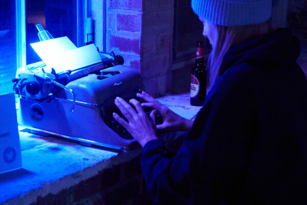 eine junge Frau sitz an einer Schreibmaschine